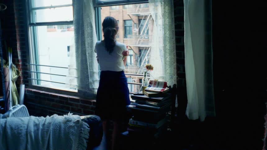 A woman stands at the window looking out