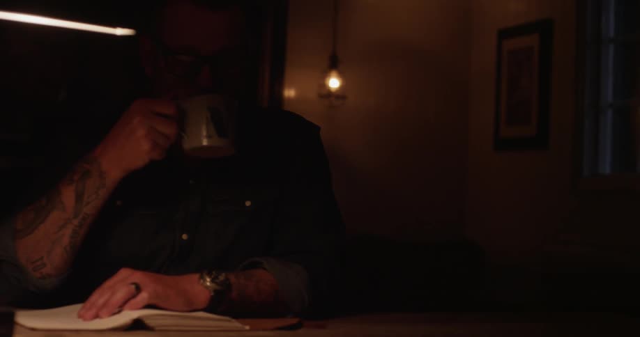 Man sitting at table writing in notebook