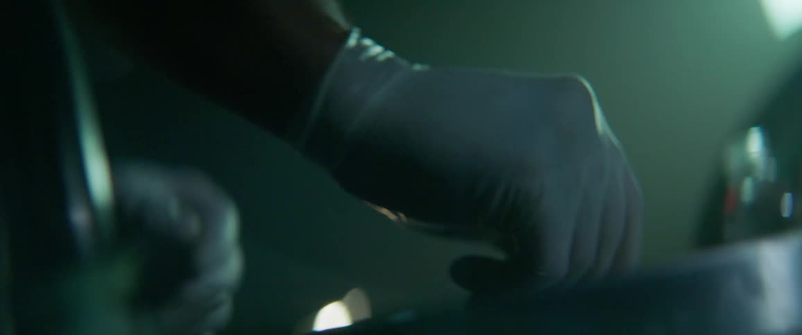 Person wearing white gloves works on something