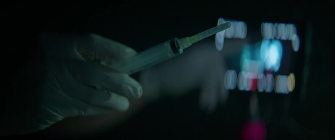 Gloved hand removes the tip from a syringe