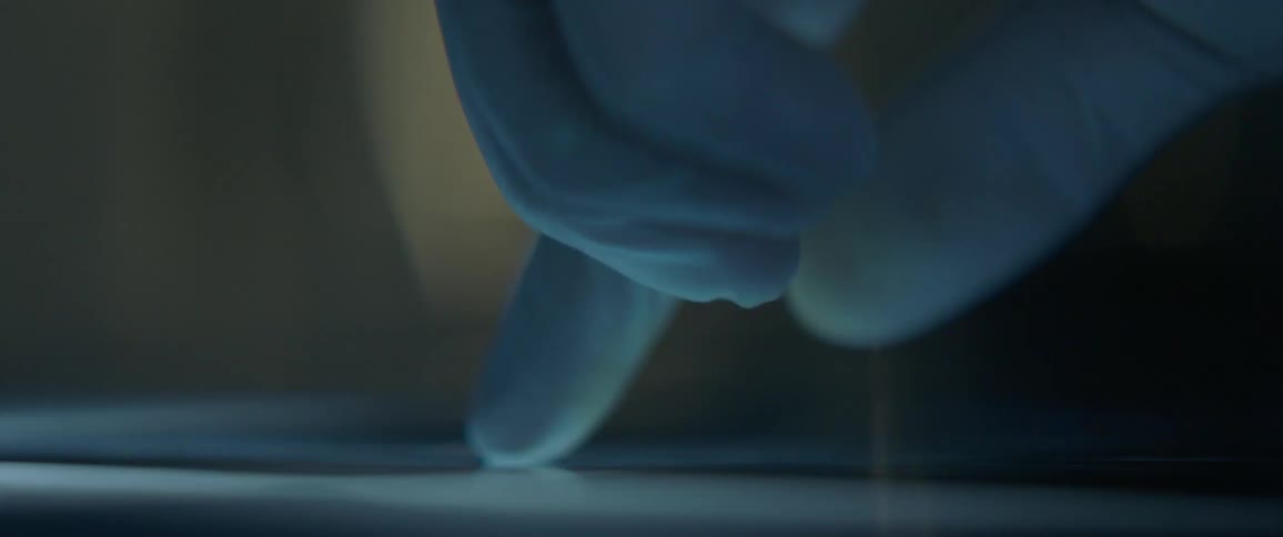 A person wearing latex gloves wipes on the surface