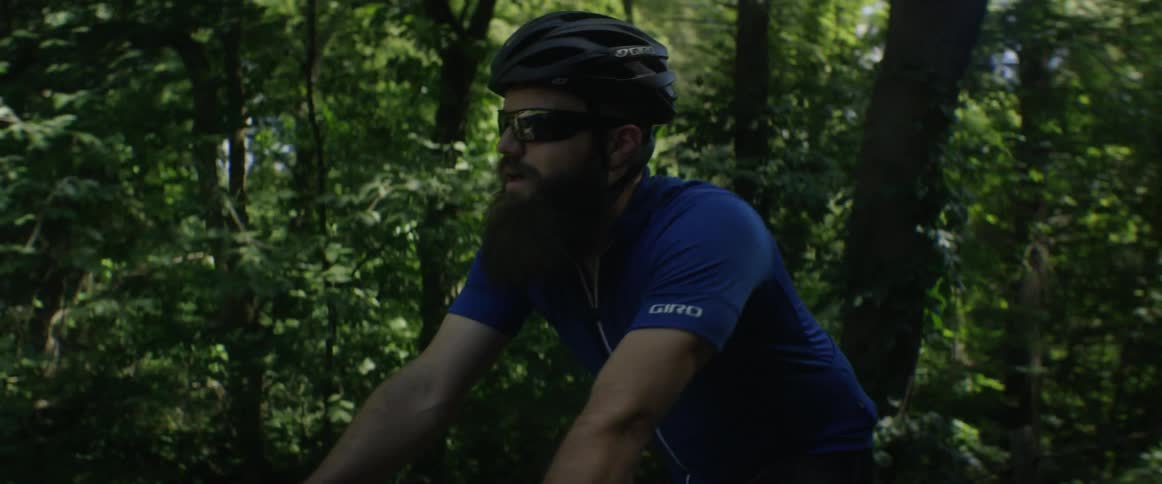 A man rides a bike through a forest