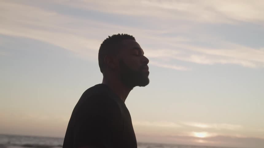 A man is standing outdoors at a beach