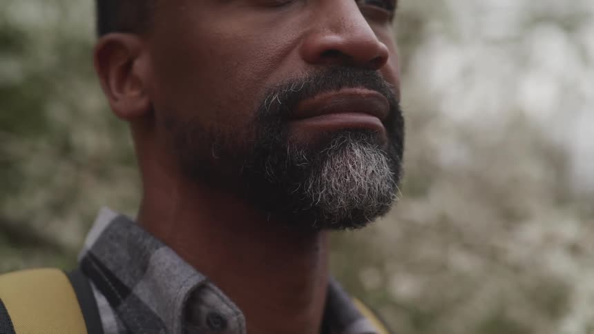 A black man outside with a backpack on