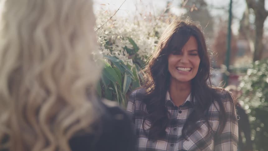 Women laughing and having a conversation outside