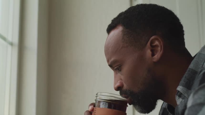 A man takes a drink from a glass
