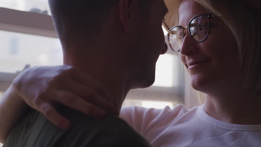 A couple dance together by the window