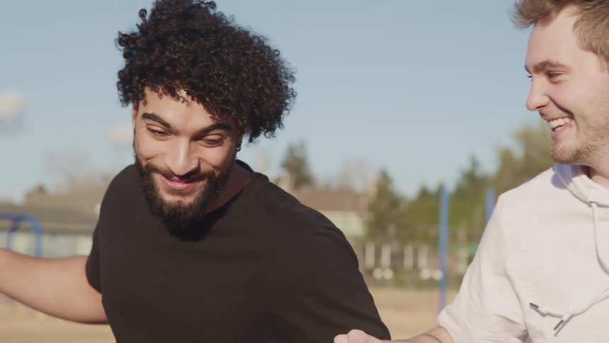 Two men walk in the park laughing