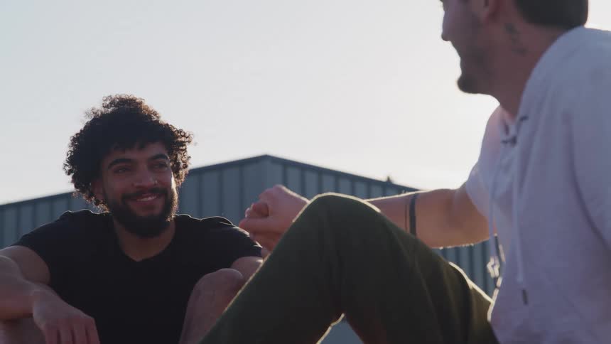 Two men shake hands outside