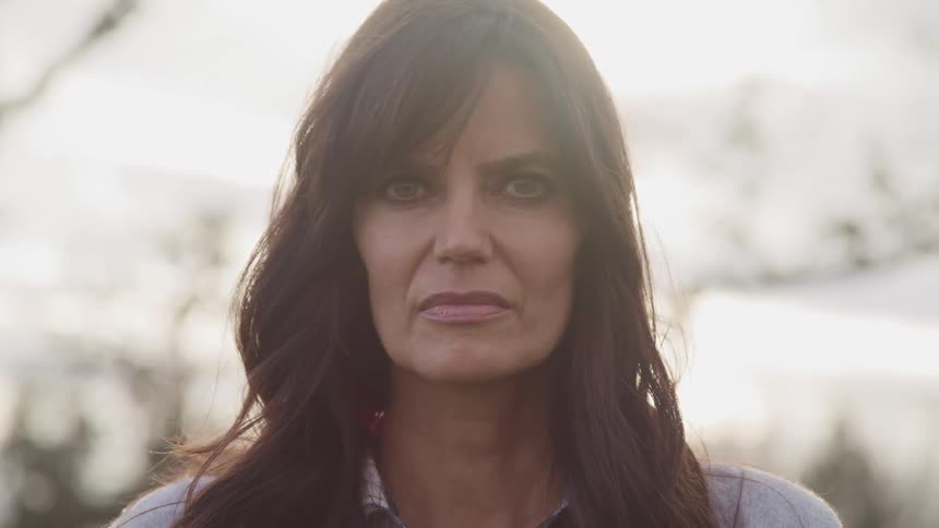 A woman stares intensely at the camera