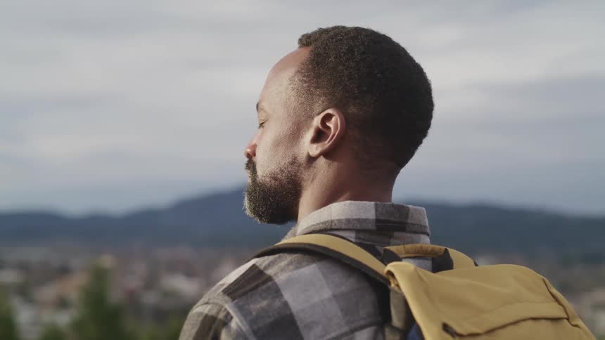 A man standing outside with his eyes closed