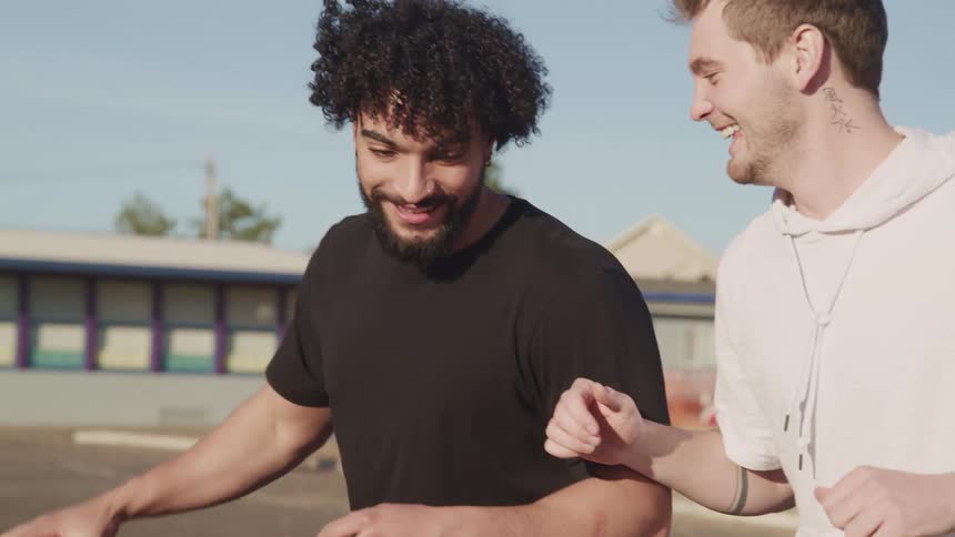 Two guys have fun playing basketball