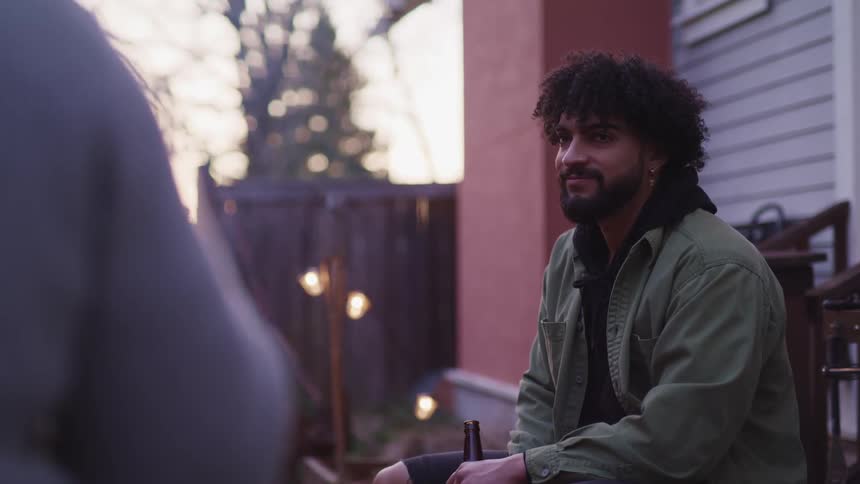 A man is sitting outside with a bottle