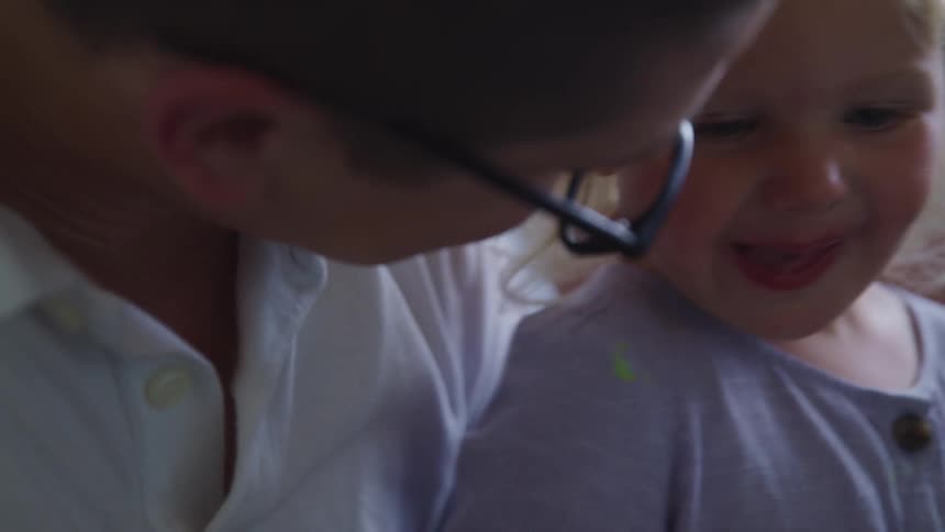 A child laughs with a man