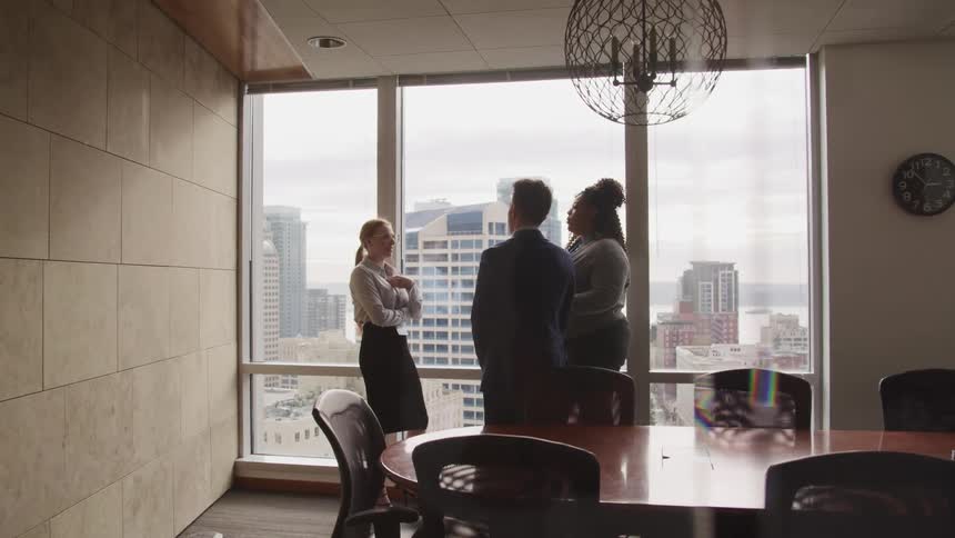 Three people in an office chatting with each other