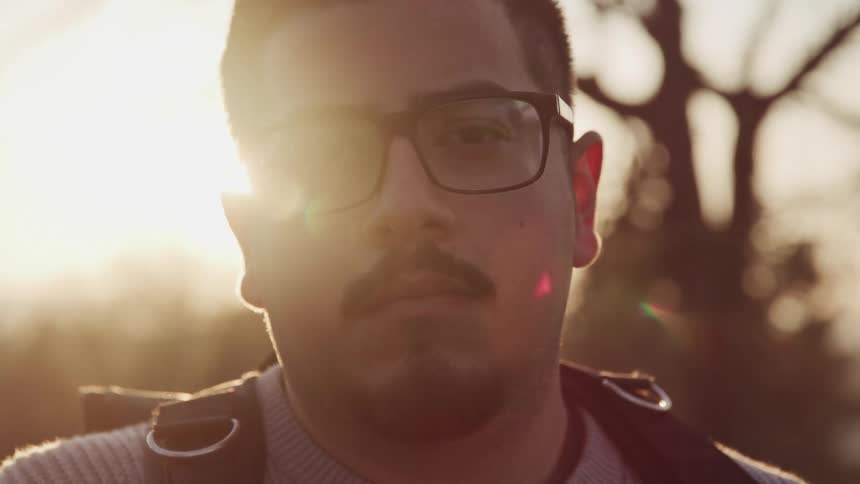 A man is outdoors while the sun is setting