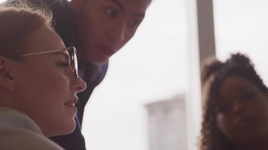 A teacher shows two students something
