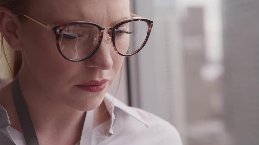 A woman indoors looks down at something