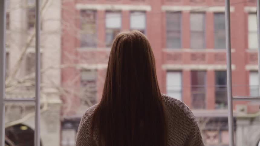 A woman is looking out the window