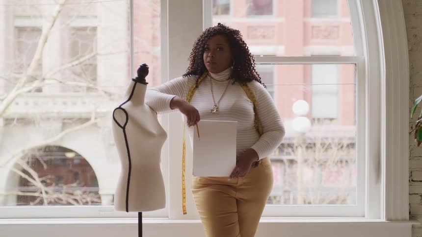 Fashion designer reclined on a mannequin in a studio on the city