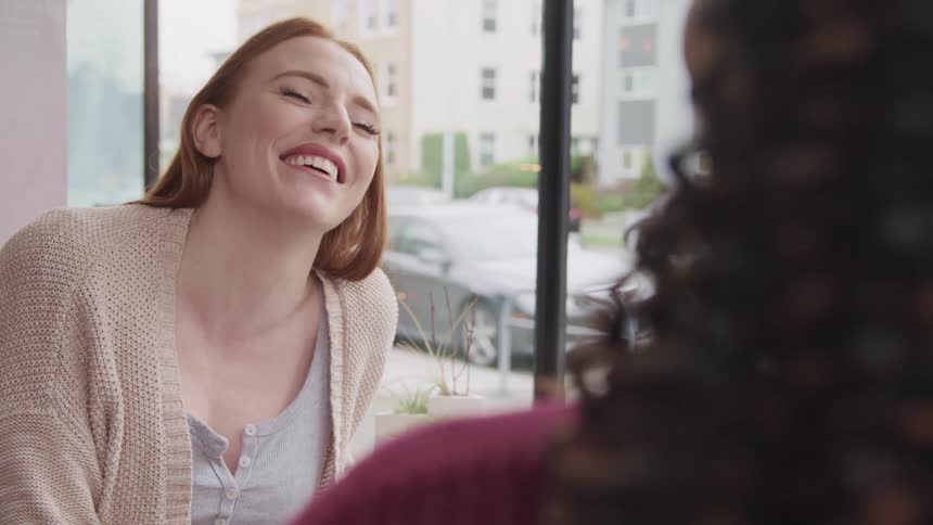 Two women talk and laugh together