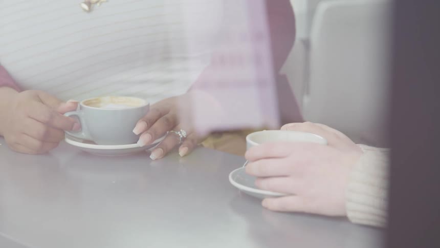 Close up of two women having coffee at a table