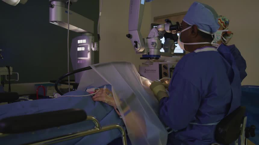 Surgeons and assistant performing surgery on a patient