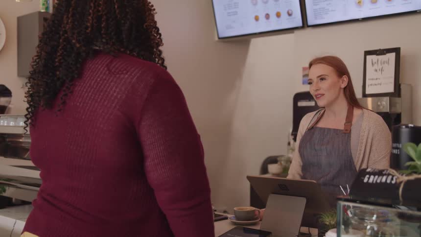 A cashier talks with a customer as she checks out