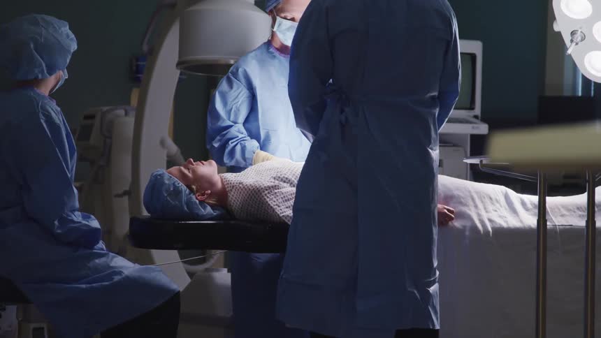 Patient lying on hospital bed while being operated on