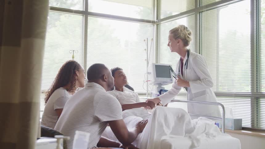 A doctor shakes hands with a patient