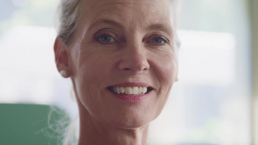 A woman turns her head while smiling