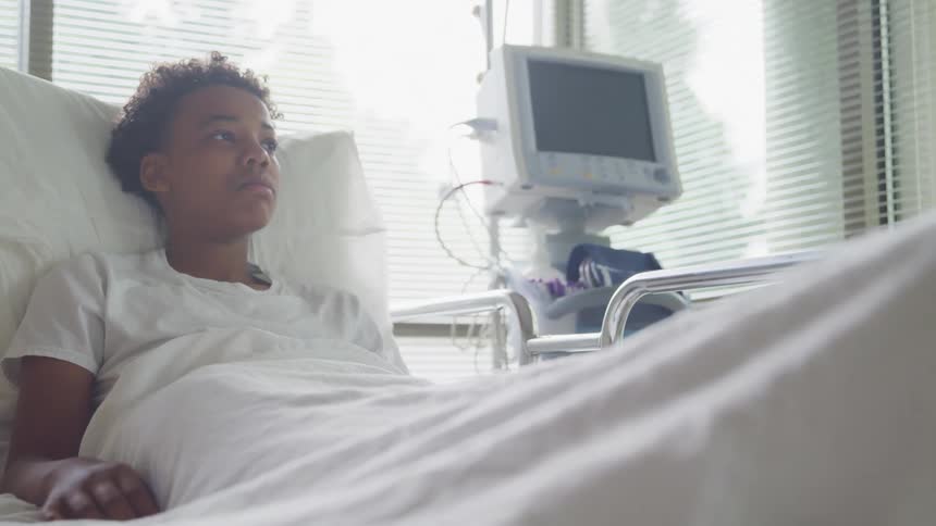 A young girl lying in a hospital bed