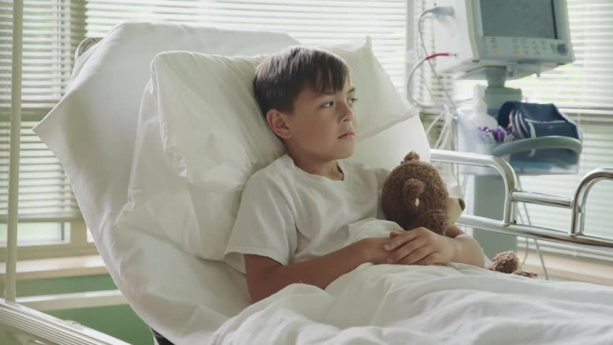A boy is resting in the hospital bed