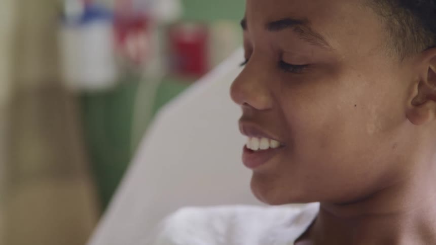 A patient smiles in the hospital bed