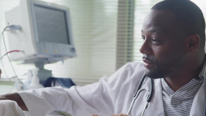 A doctor talks with a patient in a hospital bed