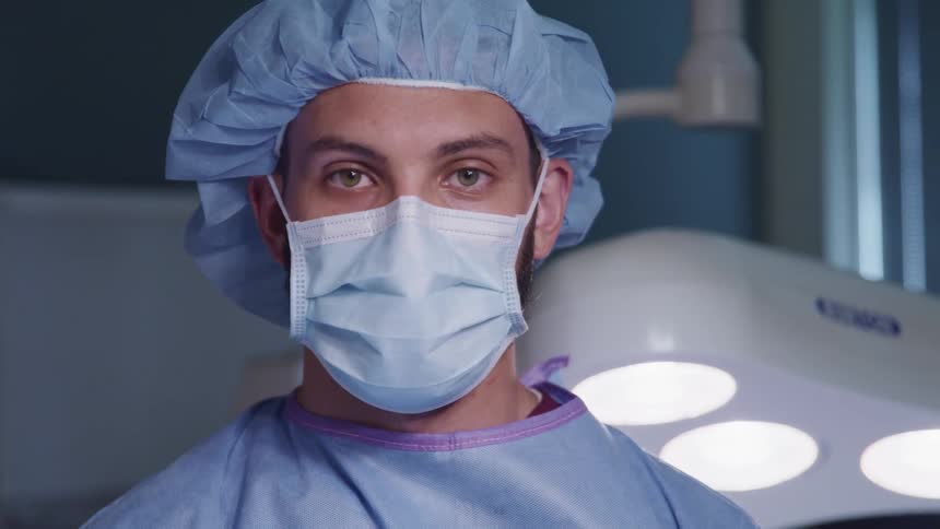 A doctor dressed in his scrubs and mask