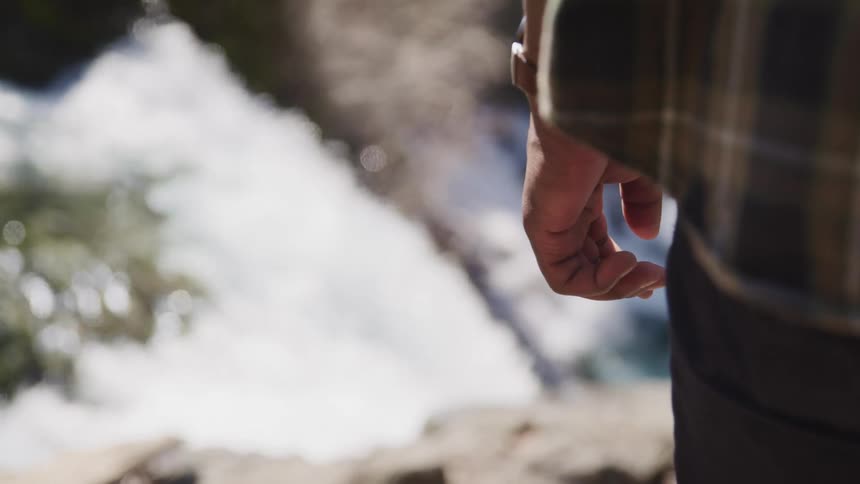 A person stands near the stream