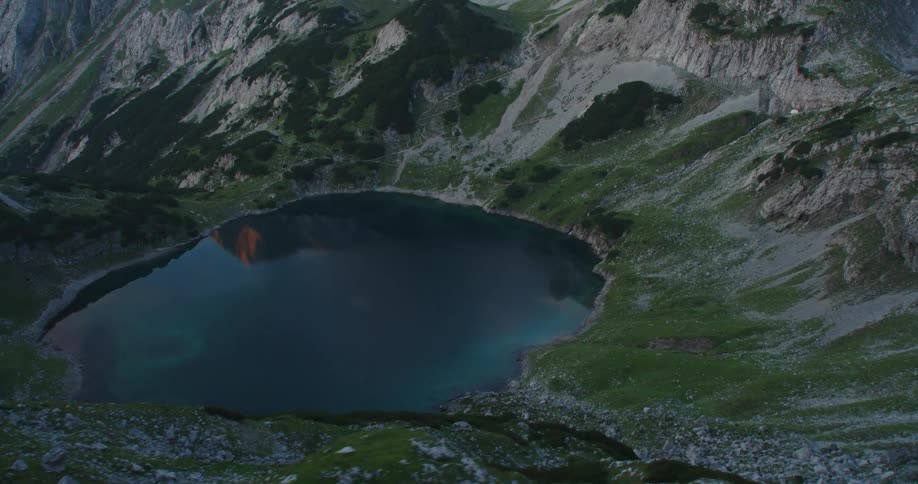 Deep blue waters of a small circular lake atop of the mountains