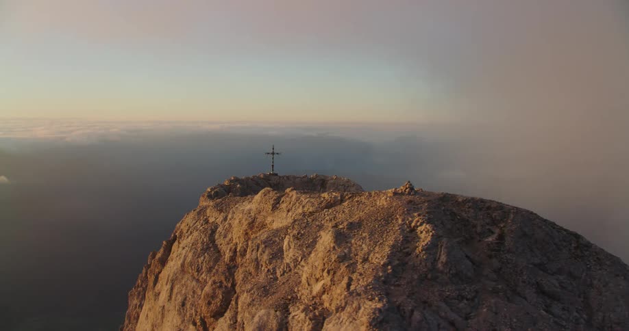 An aerial view of a mountain at dusk is displayed