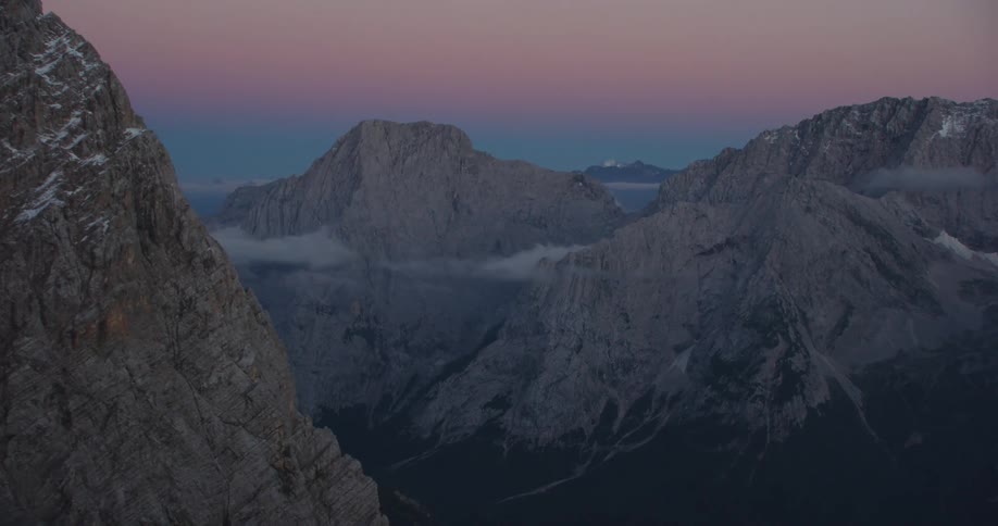A barren stone mountain ridge at sunset