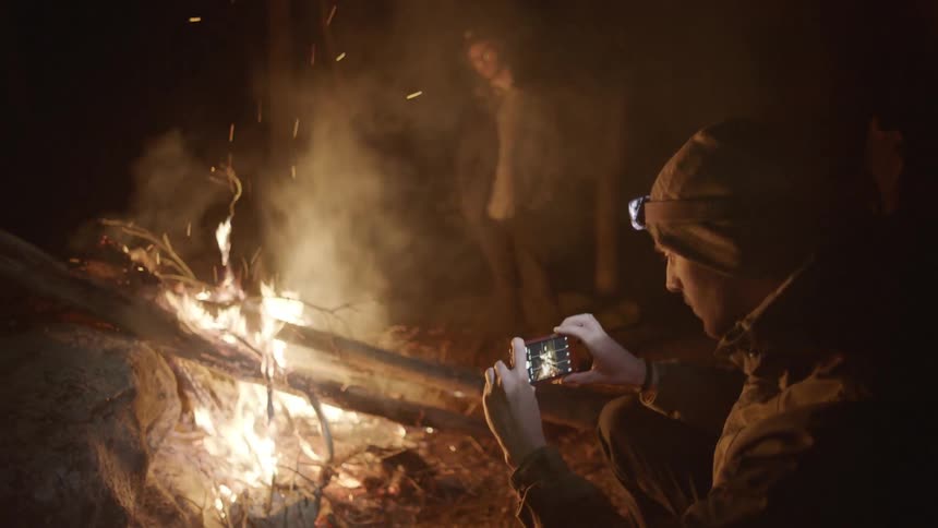 A man takes pictures of a fire