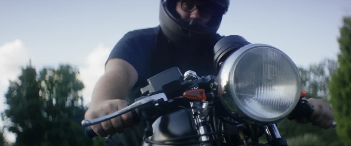 A man is sitting on a motorcycle on a sunny day