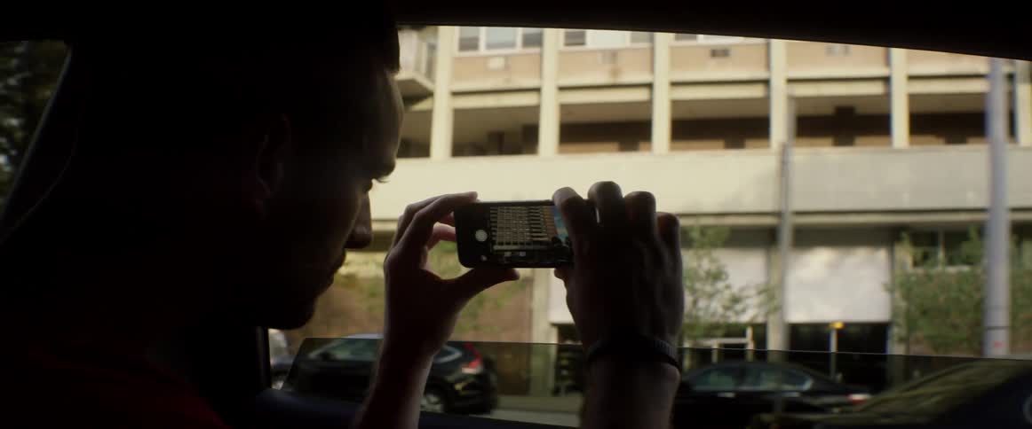 A man is taking photos from the inside of a vehicle