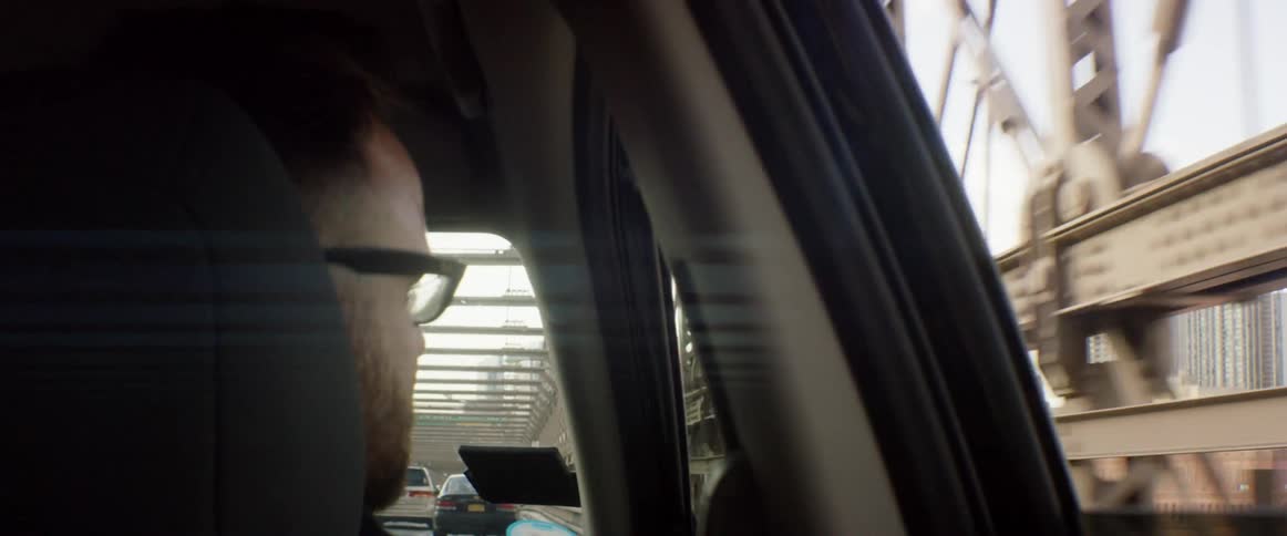 A man is looking out of the window of a moving vehicle