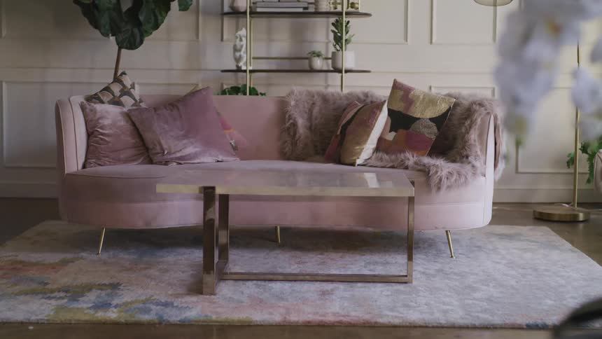 A designed and staged living room sofa with area rug and coffee table