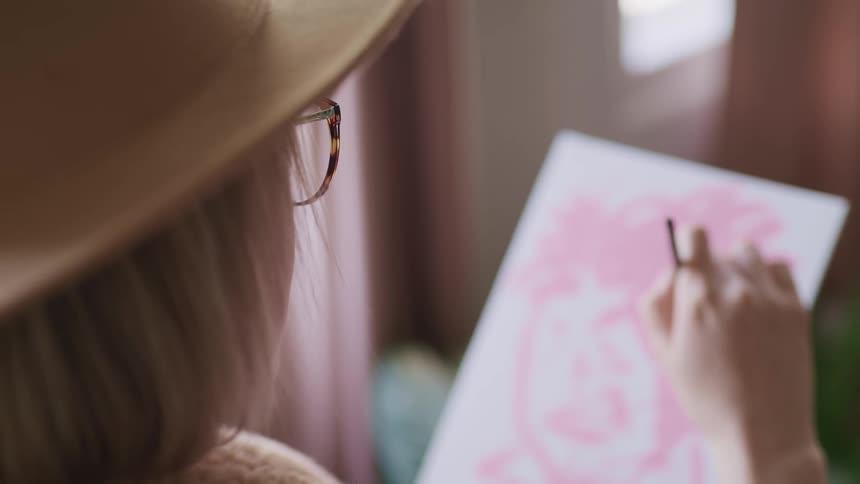 A woman sits and paints a picture