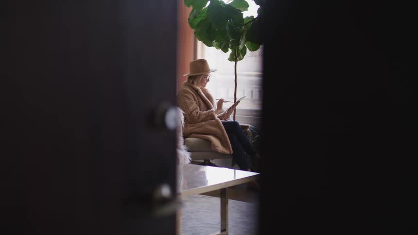 A woman sits at home and paints