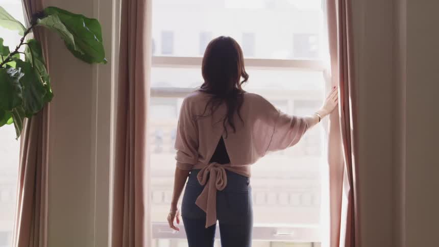 Woman looks out a window and watches a cruise ship go by