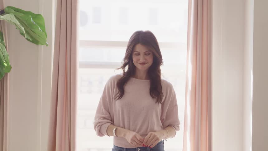 A woman smiles by the window