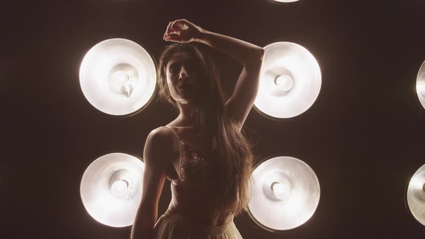 A woman is dancing in a room filled with lights